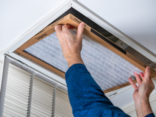 A man replacing an HVAC air filter in Salem, OR